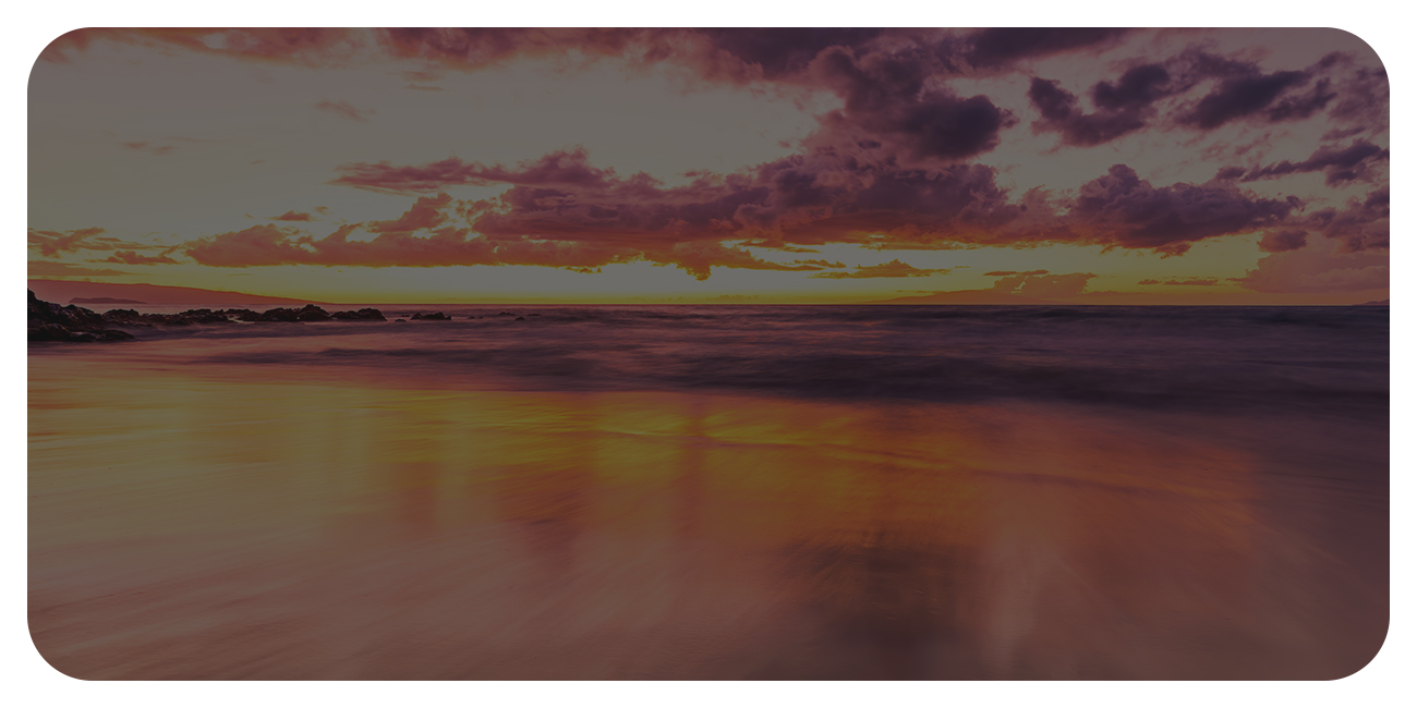 A tranquil beach scene featuring a colorful sunset