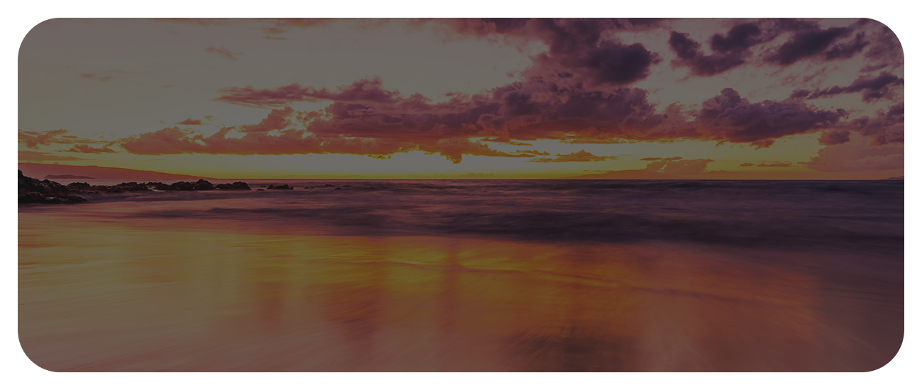 A tranquil beach scene featuring a colorful sunset